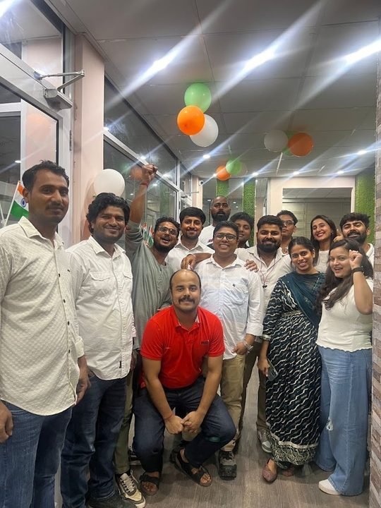 Team celebrating Independence Day in an office decorated with tricolour balloons.